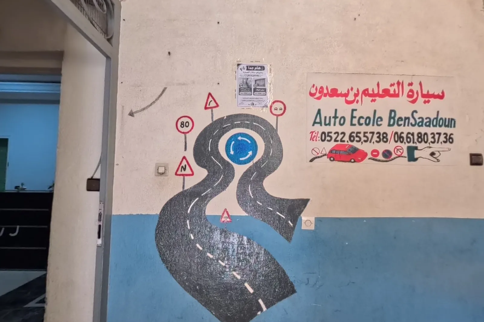 جدارية المدخل: طريق ومدار مرسومان مع الرقمين 0522655738 و0661803736